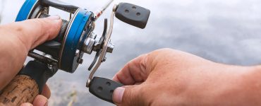 person fishing with a baitcasting rod and reel