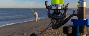 people surf fishing on a beach