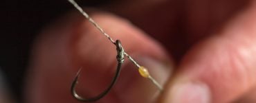 person tying a line on a hook