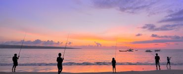 people surf fishing on the beach