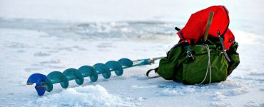 electric ice auger laying in the snow