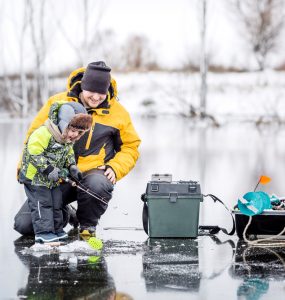 family ice fishing on a lake