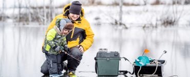 family ice fishing on a lake