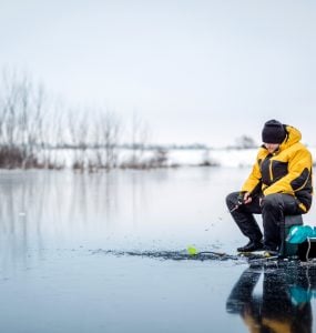 guy ice fishing on lake