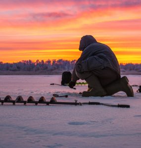 person setting an ice fishing line on a lake in wisonsin