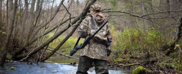 person in camo duck hunting waders