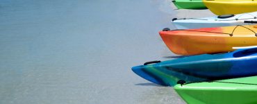 kayaks lined up on the beach shoreline