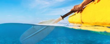 person paddling a fishing kayak