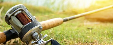 a baitcaster fishing rod laying in the grass
