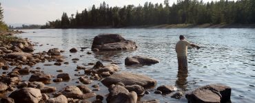 person fly fishing on a lake in montana