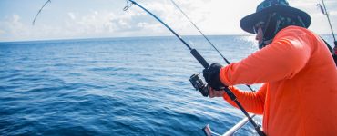 person using a saltwater fishing rod on a boat